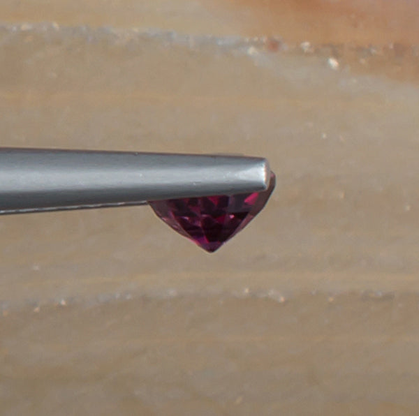 0.79ct Malaya Garnet Colored Gemstone Side View Natural Background 
