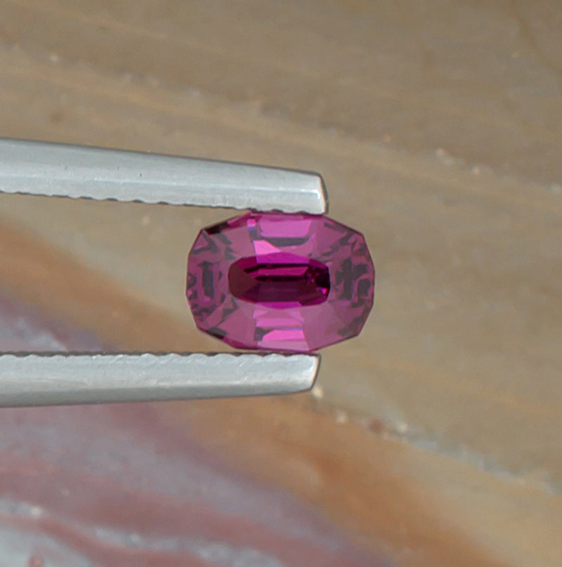 0.88ct Rhodolite Garnet Colored Gemstone Top View Natural Background