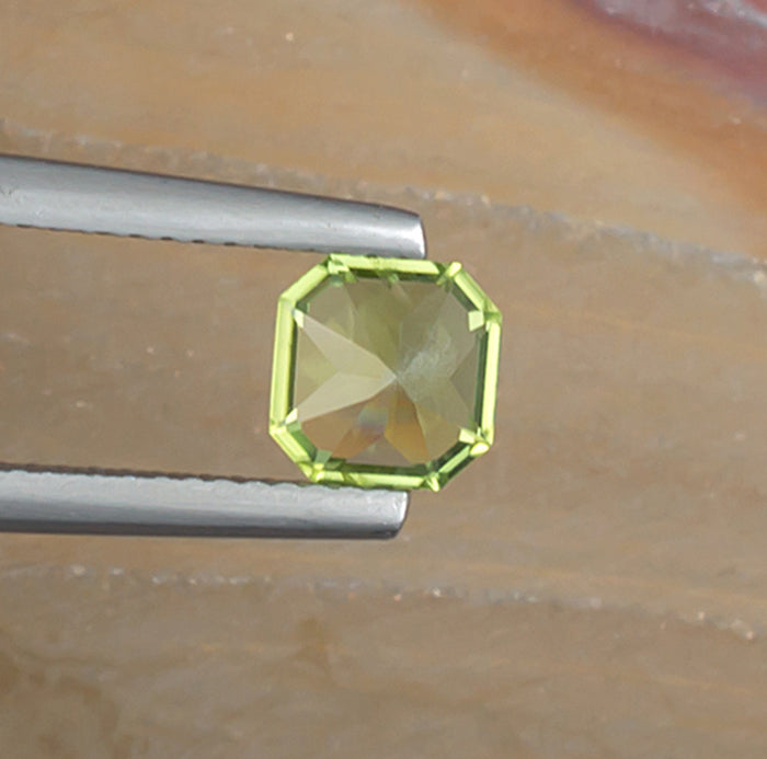 1.10ct Peridot Colored Gemstone Bottom View Natural Background 
