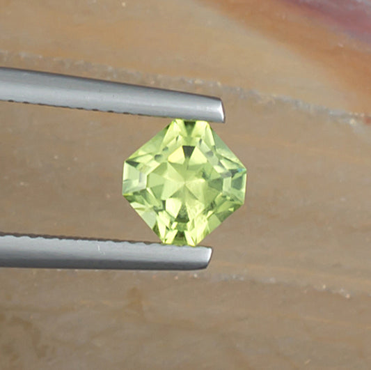 1.10ct Peridot Colored Gemstone Top View Angle Natural Background
