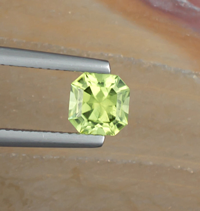 1.10ct Peridot Colored Gemstone Top View Natural Background 
