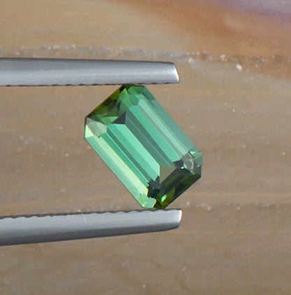 1.24ct Green Tourmaline Colored Gemstone Top View Angle Natural Background 
